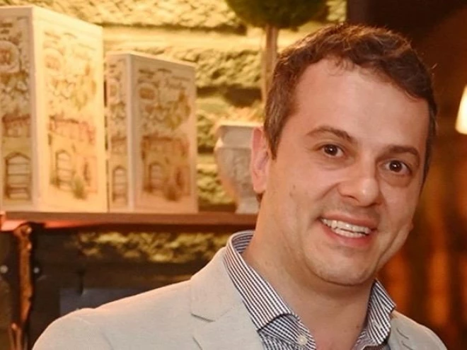 Paulo Spanholi Júnior, empresário e diretor da Asia Metals, está de cabelos curtos e camisa listrada, usando blazer claro, aparece sorrindo em primeiro plano.