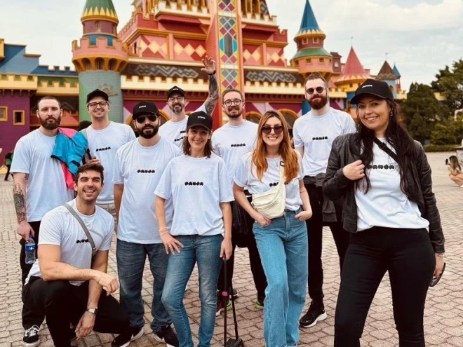 Equipe da Panda Branding posa diante de um castelo durante viagem ao Beto Carrero World. Os integrantes usam camisetas da empresa e aparecem sorrindo para a foto.